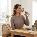 Woman drinking from a Contigo Cortland 2.0 AUTOSEAL water bottle at a sunlit desk.